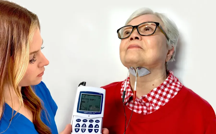Ampcare ESP cihazı ile bir klinisyenin hastaya nöromüsküler elektrik stimülasyonu uyguladığı tedavi anı